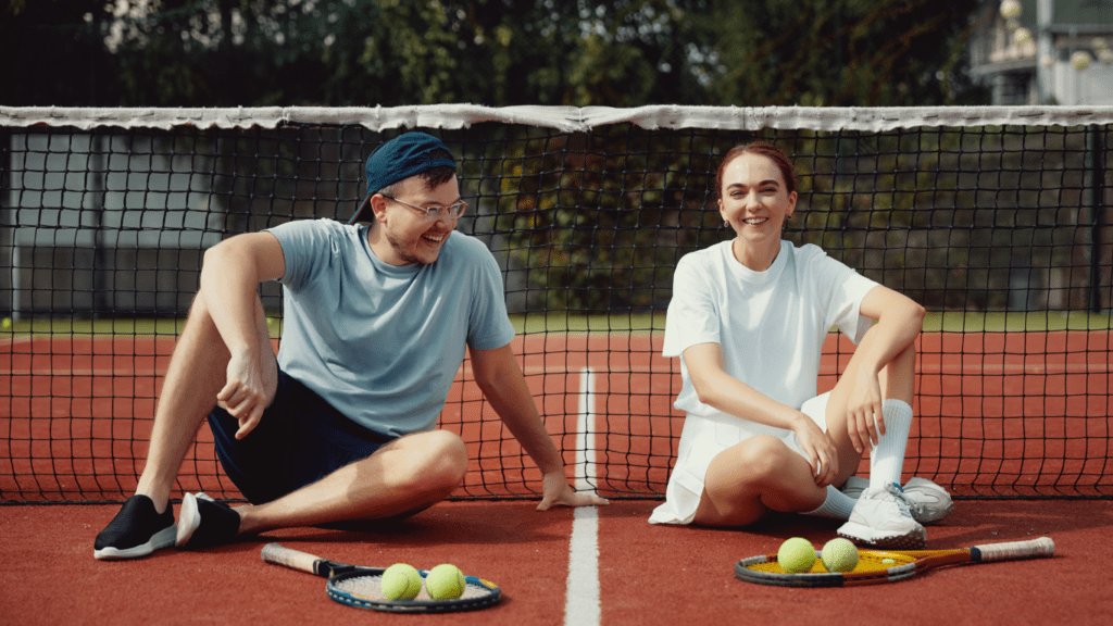 couple sitting in a tennis court 